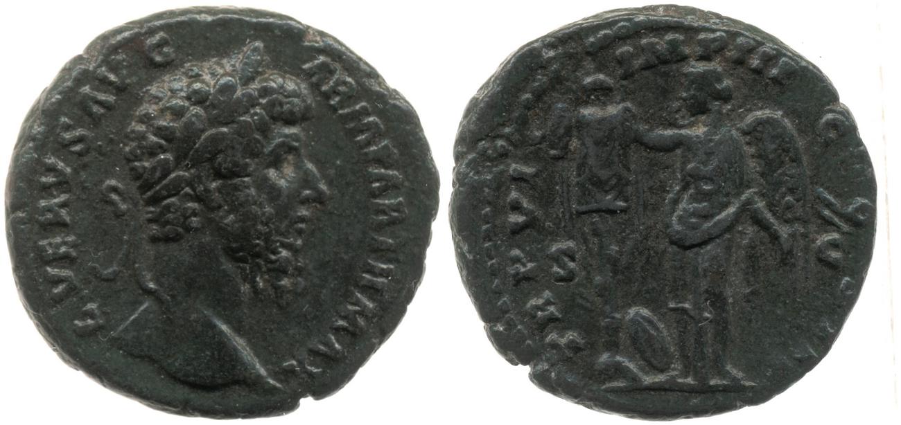 Obverse: Head of Lucius Verus, laureate, right. Reverse: Victory, winged, draped, standing left, setting right hand on trophy, at base of which is a shield